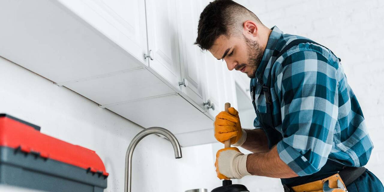 selective-focus-of-repairman-holding-plunger-in-ki-resize.jpg