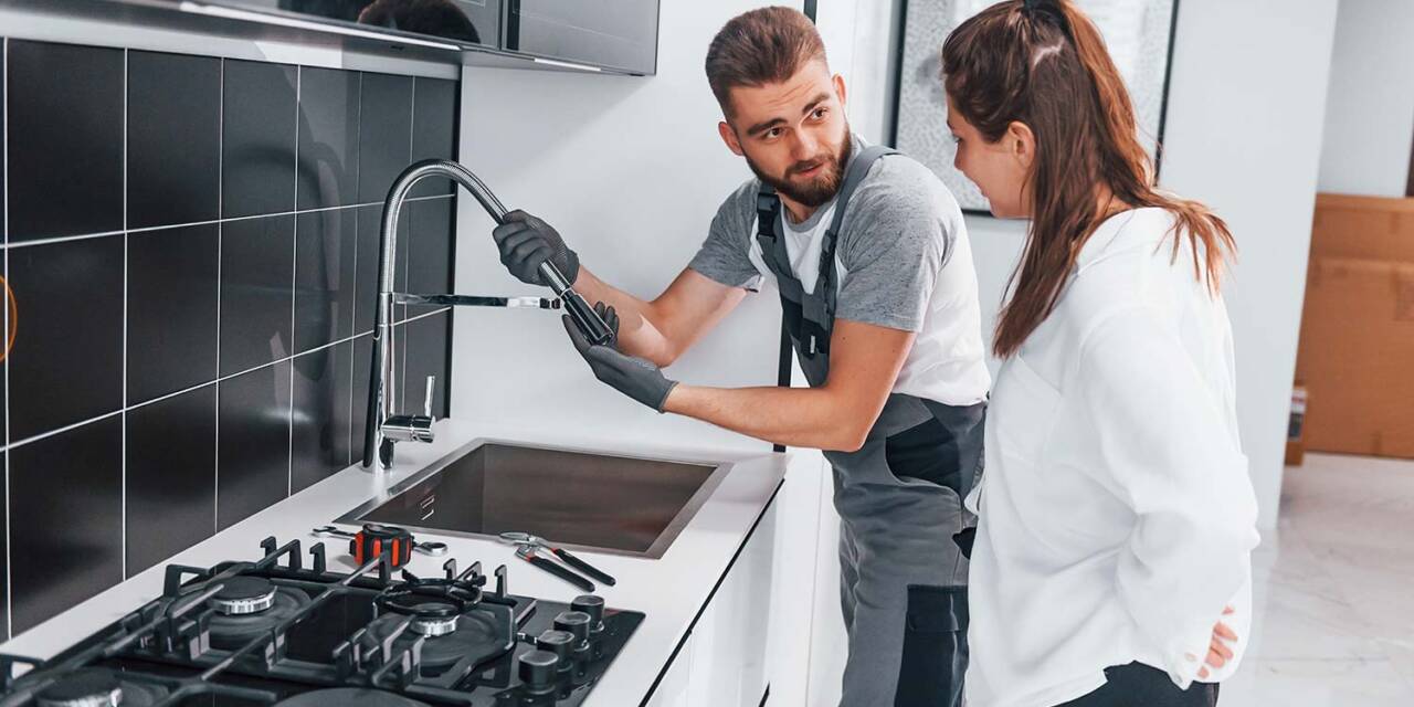 young-professional-plumber-in-grey-uniform-shows-r-resize.jpg